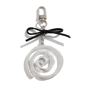 Détail d'un porte-clés spirale argenté avec un nœud en velours noir et un fermoir homard