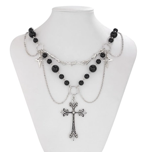 Dettaglio collana punk gotica con croce d'argento e ciondoli a stella su modello
