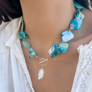 Dettaglio della collana stile oceano con pezzi di conchiglia blu e perla barocca