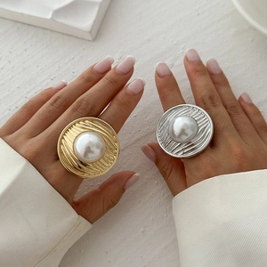 Nahaufnahme klobiger Gold- und Silberringe mit Perlen auf Fingern im modernen Stil