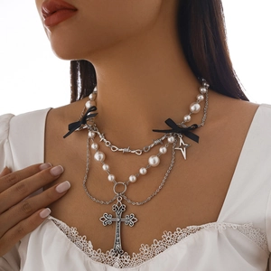 Dettaglio collana gotica multistrato con pendente a croce, perle e fiocchi neri