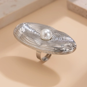 Detaillierte Nahaufnahme des silbernen Wellenrings mit großer Perle und Metallstruktur