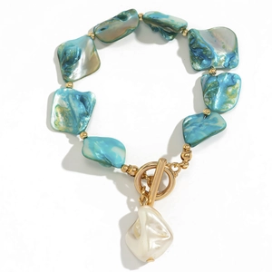 Dettaglio della collana con conchiglie verde acqua, perline dorate e chiusura perla barocca
