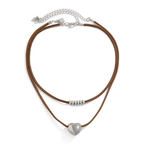 Close-up of double-layer necklace with silver heart pendant and woven brown cords