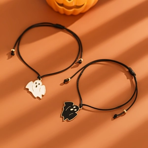 Dettaglio di braccialetti fantasma regolabili con bordi dorati su sfondo arancione zucca