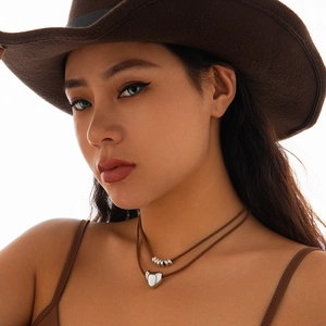 Close-up of double-layer necklace with silver heart pendant and beads on a model