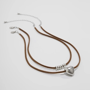 Dettaglio della collana a doppio strato in pelle scamosciata marrone con cuore argento