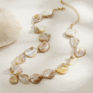 Dettaglio della collana bohémien con perle di conchiglia e ciondolo dorato a conchiglia