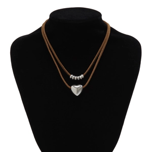 Detail view of double-layer necklace with silver heart pendant on brown velvet cord