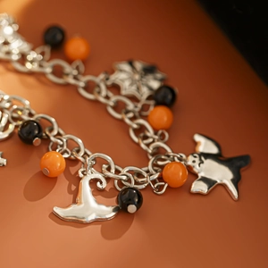 Primo piano del bracciale di Halloween con cappello da strega d'argento e ciondoli fantasma
