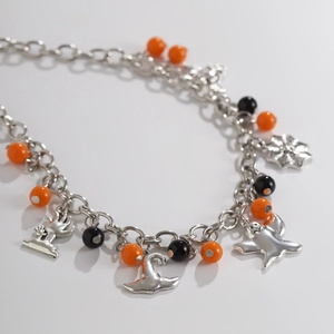 Dettaglio macro della collana di Halloween con ciondoli a fantasma e perline arancioni