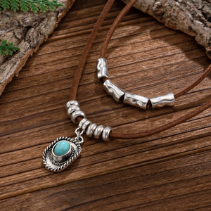 Close-up of bohemian brown suede cord necklace with turquoise western cowboy hat charm