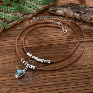 Bohemian double-layer necklace with turquoise pendant and brown suede cords on wood base