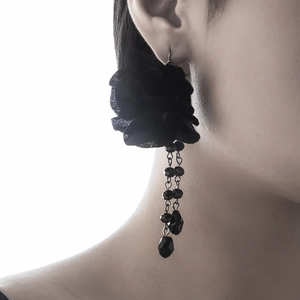 Detail view of gothic black fabric flower earrings with beaded tassels on a model