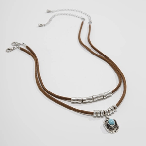 Dettaglio choker bohémien in velluto con ciondolo a cappello da cowboy e pietra turchese