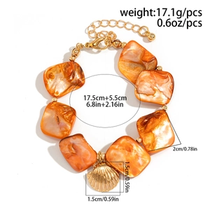 Detail of ocean-style bracelet with orange shell tiles, gold beads, and shell pendant