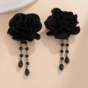 Detailed close-up of gothic black fabric rose earrings with beaded fringe and teardrop pendants