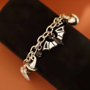 Dettaglio del bracciale di Halloween con pipistrello in smalto e cappello da strega su velluto