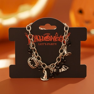 Dettaglio del bracciale con ciondoli di Halloween con denti da vampiro, cappello da strega e pipistrello