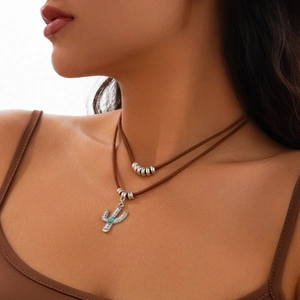 Detail of bohemian layered necklace with silver cactus pendant and turquoise stone inlay