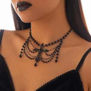 Detail of gothic black beaded necklace with vintage floral motif and layered tassels