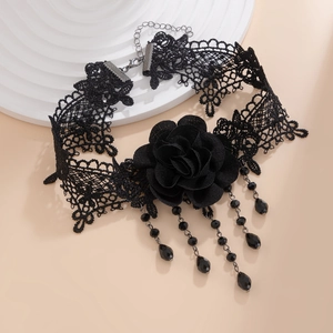 Gothic black lace choker with a fabric rose and hanging beaded tassels in a top-down view