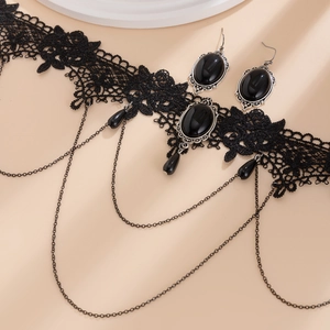 Detail of gothic black lace choker with dark gemstone pendant and tassel teardrop beads