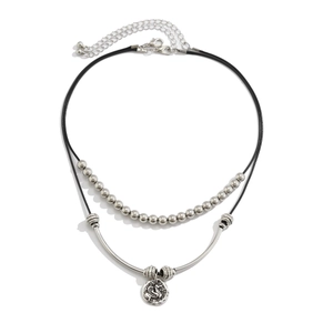 Detail of double-layer choker featuring a dragon pendant and polished metal tube