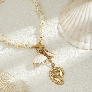 Detail der Muschelkette mit goldenem Nautilus-Anhänger und Seestern-Perlen