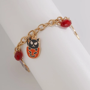 Dettaglio della collana di Halloween con catena dorata, gatto nero e ciondolo zucca