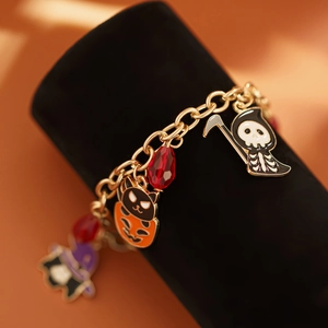 Bracciale Halloween con ciondoli zucca e scheletro su supporto di velluto nero