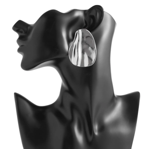 Gros plan de boucles d'oreilles irrégulières en métal argenté portées sur un mannequin