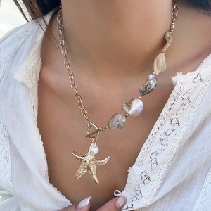 Detail einer Boho-Seesternkette mit schillernden Perlen und goldenem Knebelverschluss