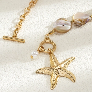 Makroaufnahme des goldenen Seestern-Anhängers mit Barockperlen und T-Verschluss-Kette