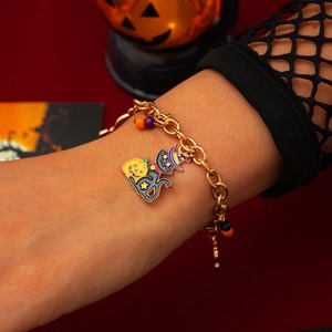 Dettaglio del bracciale dorato di Halloween con gatto nero mago e ciondolo a zucca