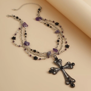 Detail view of gothic multilayer silver necklace with purple stones and cross pendant