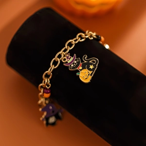 Dettaglio macro bracciale Halloween con charms zucca e gatto su catena dorata