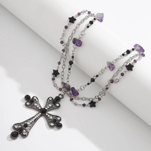 Macro view of gothic triple-layer necklace with cross pendant and purple crystals