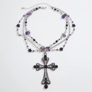 Detail of gothic silver cross pendant with purple crystals and multi-layer punk chains
