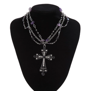 Detail of gothic silver cross necklace with purple crystal beads and black star charms
