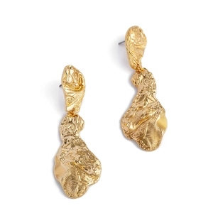 Détail de boucles d'oreilles dorées texturées au design moderne en métal fondu épuré