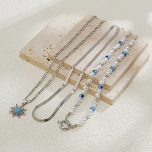 Detailansicht der Perlenkette, Schlangenkette und Sonnenanhänger mit blauen Steinen