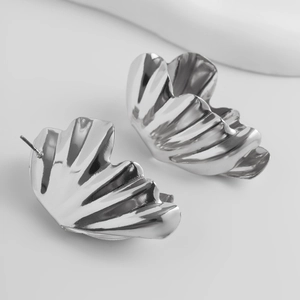 Gros plan de boucles d'oreilles plissées argentées avec finition miroir polie