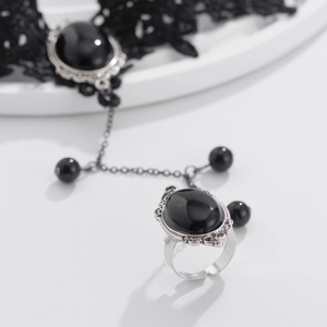 Detail of gothic lace bracelet with black gemstone ring and delicate silver chain