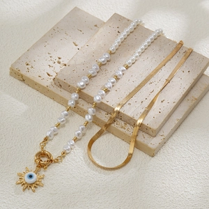 Detail der Perlenkette mit Sonnen-Anhänger und goldener Schlangenkette im Set