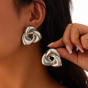 Gros plan de boucles d'oreilles géométriques argentées au design en métal froissé