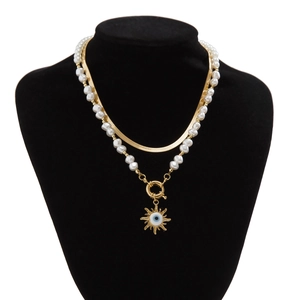 Details von mehrlagiger goldener Schlangenkette und Perlenkette mit Sonnen-Anhänger