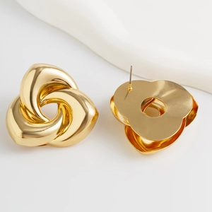 Détails macro de grandes boucles d'oreilles géométriques dorées avec métal poli