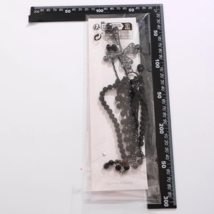 Gothic black beaded waist chain with silver metal cross pendant in retail packaging