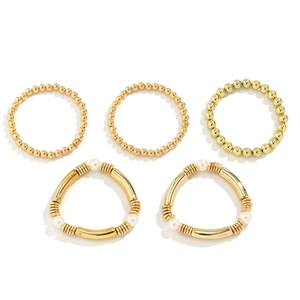Detalle del juego de 5 pulseras de cuentas doradas con perlas y tubos de metal